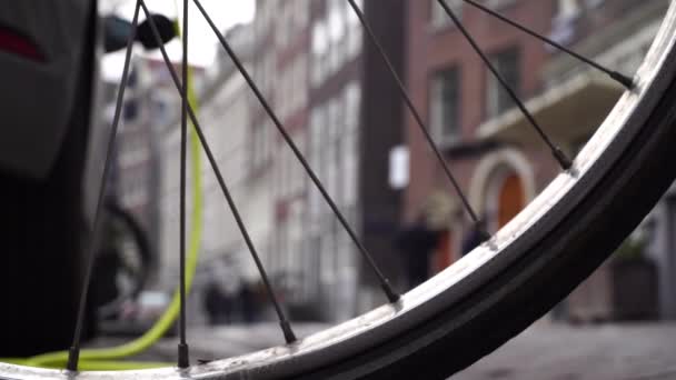 Carga de coche eléctrico en el fondo una rueda de bicicleta en Amsterdam — Vídeo de stock