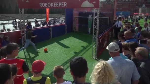 MOSCOW, - July 1: Girl scores a goal for the robot goalkeeper in fan zone at the Red Square during FIFA World Cup 2018. July 1, 2018 in Moscow, Russia. — Stock Video