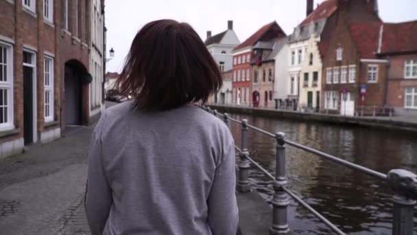 Mädchen spaziert und betrachtet Sehenswürdigkeiten in der belgischen Stadt Brügge. Zeitlupe — Stockvideo