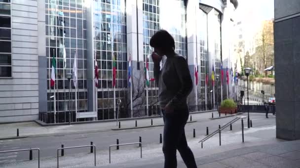 A senhora deputada está a caminhar e a falar ao telefone, perto do Parlamento Europeu, em Bruxelas. Bélgica. câmara lenta . — Vídeo de Stock