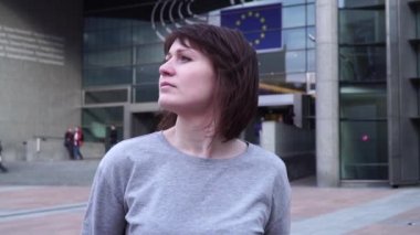 Turist kız ve Brüksel'deki Avrupa Parlamentosu görünüyor. Belçika. ağır çekim. Dolly zoom etkisi