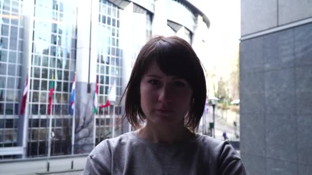 Senhora turista caminha e olha para atrações perto do Parlamento Europeu em Bruxelas. Bélgica. câmara lenta . — Vídeo de Stock