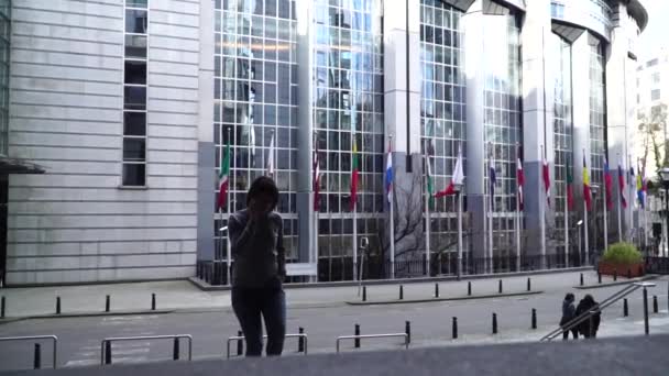Señora está caminando y hablando por teléfono cerca del Parlamento Europeo en Bruselas. Bélgica. cámara lenta . — Vídeo de stock