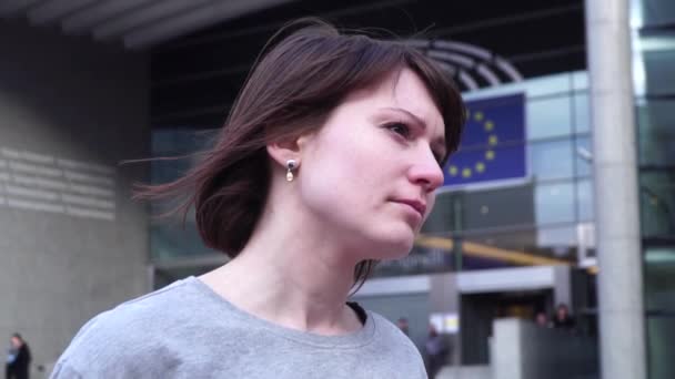 Turystyczna pani idzie i patrzy na atrakcje w pobliżu Parlamentu Europejskiego w Brukseli. Belgia. efekt powiększenia powolny motion.dolly. — Wideo stockowe