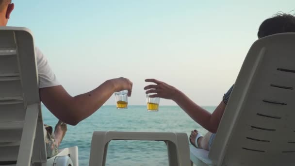Crop couple clinking with drinks on beach — Stock Video
