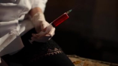 Korkunç doktor kan lekeli ve bandaj ile bir göz, kan şırınga tutar