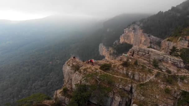 A group of climbers enjoy the views while sitting on the edge — Stock Video