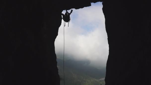 Klättrare siluett fallande klippa av rep på himmel bakgrund — Stockvideo
