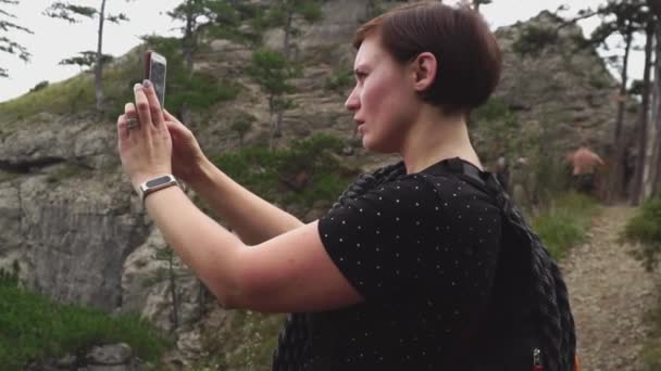 Mujer viajando, haciendo foto de hermoso bosque verde y montañas paisaje de la naturaleza en el teléfono inteligente . — Vídeos de Stock