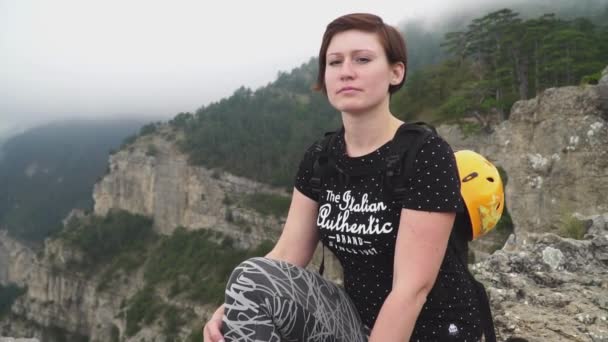 Jovem mulher sentada no topo da montanha olhando para a bela paisagem no dia de verão. câmara lenta — Vídeo de Stock