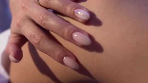 Hand of young girl with nice manicure touch smooth skin of feet — Stock Video