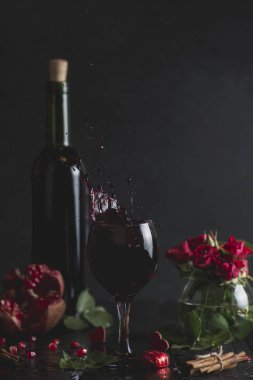 Bir bardak kırmızı şarap. Romantik akşam bir kadeh şarap Sevgililer günü için ile. Tatil kompozisyon bir siyah tablo ve arka plan üzerinde. İçki sıçrama