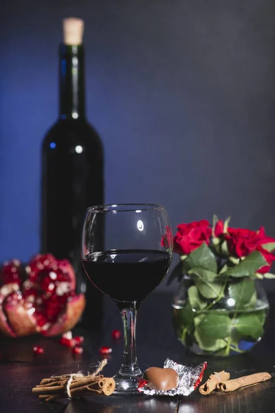 Red wine in a glass. Romantic evening with a glass of wine to Valentine\'s day.Holiday composition on a black table  and  background.
