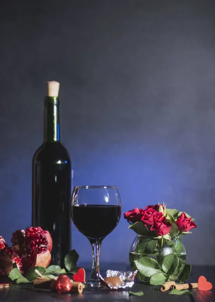 Red wine in a glass. Romantic evening with a glass of wine to Valentine\'s day.Holiday composition on a black table  and  background.