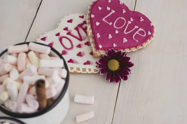 Romantic breakfast for valentine day. A delicious drink of marshmallows and heart-shaped cookies. Breakfast for lovers on a white  wooden table