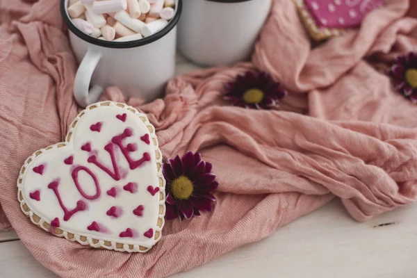 Romantic breakfast for valentine day. A delicious drink of marshmallows and heart-shaped cookies. Breakfast for lovers on pink textile