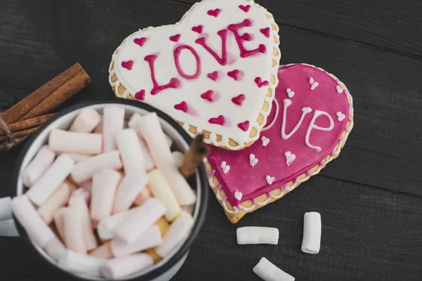 Romantic breakfast for valentine day. A delicious drink of marshmallows and heart-shaped cookies. Breakfast for lovers on a wooden table