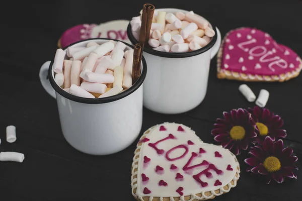 Romantic breakfast for valentine day. A delicious drink of marshmallows and heart-shaped cookies. Breakfast for lovers on a wooden table