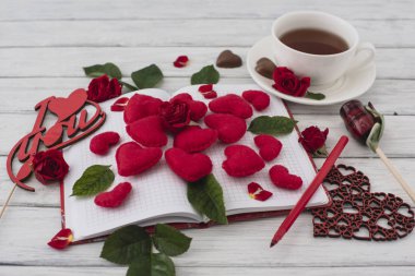 Sevgililer günü. Kırmızı kalpler bir beyaz tahta masada dizüstü bilgisayar. Romantik aşıklar günü sabahı. Üstten görünüm