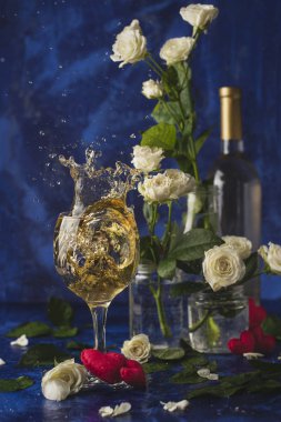 Sevgililer günü. Beyaz şarap. Romantik akşam. Şarap, bir demet beyaz gül ve mavi bir arka plan üzerinde kırmızı kalpler. Tatil severler. İki kişi için lezzetli bir alkollü içecek. Resmi fotoğraf.