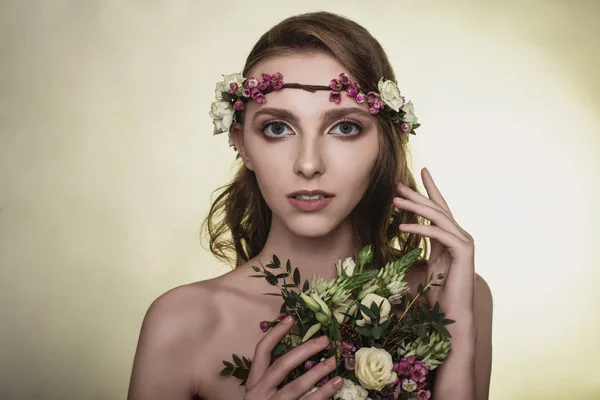 Spring, summer fashion photo shoot at the studio. Beautiful girl with flowers in the background.Tenderness, beauty on the pictures.Beautiful model.Spring composition of natural flowers.Portrait