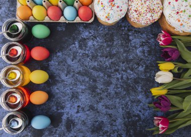 Easter.Cakes, renkli yumurta, Bahar laleler, mavi zemin üzerine kek. Tatil ayarla. Dini günün kutlu olsun insanlar için geleneksel. Üstten Görünüm. Uzay kopyalayın. Kavramı