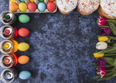 Easter.Cakes, renkli yumurta, Bahar laleler, mavi zemin üzerine kek. Tatil ayarla. Dini günün kutlu olsun insanlar için geleneksel. Üstten Görünüm. Uzay kopyalayın. Kavramı