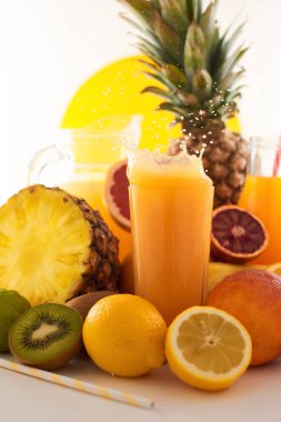 Taze meyve suyu dinamik sıçrama. Beyaz bir arka planda bir bardak meyve içeceği ve meyve. Lezzetli, lezzetli, tatlı yaz seti. 