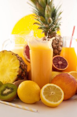 Taze meyve suyu dinamik sıçrama. Beyaz bir arka planda bir bardak meyve içeceği ve meyve. Lezzetli, lezzetli, tatlı yaz seti. 