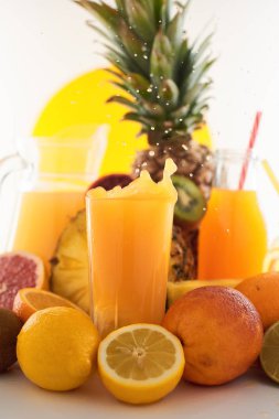 Taze meyve suyu dinamik sıçrama. Beyaz bir arka planda bir bardak meyve içeceği ve meyve. Lezzetli, lezzetli, tatlı yaz seti. 