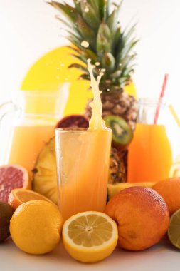 Taze meyve suyu dinamik sıçrama. Beyaz bir arka planda bir bardak meyve içeceği ve meyve. Lezzetli, lezzetli, tatlı yaz seti. 