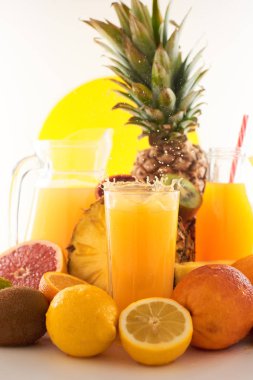 Taze meyve suyu dinamik sıçrama. Beyaz bir arka planda bir bardak meyve içeceği ve meyve. Lezzetli, lezzetli, tatlı yaz seti. 