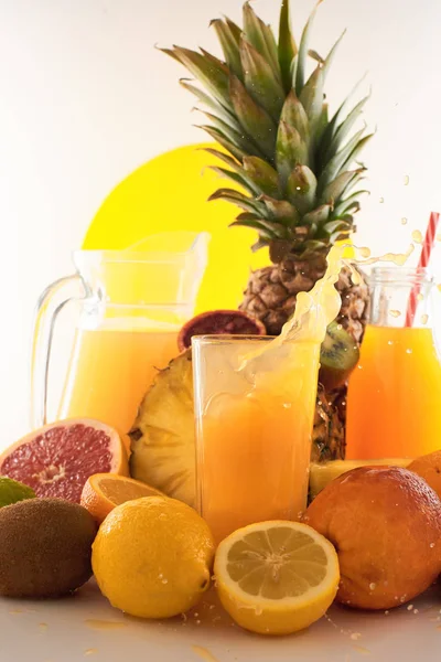 Taze meyve suyu dinamik sıçrama. Beyaz bir arka planda bir bardak meyve içeceği ve meyve. Lezzetli, lezzetli, tatlı yaz seti. 