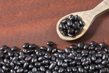 Ahşap arka plan üzerinde ham siyah fasulye
