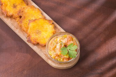 Patacon veya toston kızarmış ve yeşil muz, geleneksel snack veya Karayipler, guacamole ve domates soğan salata eşliğinde parçalar dümdüz