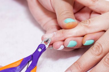 Closeup parmak tırnak bakım Güzellik Salonu manikür uzmanı tarafından. Manikürcü kütikül profesyonel makaslar, manikür ve pedikür için temizleyin.