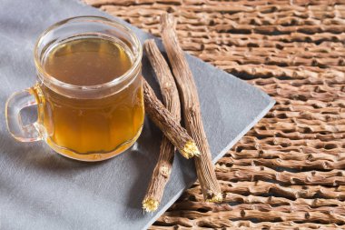 Meyan kökü kaynaklanıyor - Glycyrrhiza glabra. Ahşap arka plan