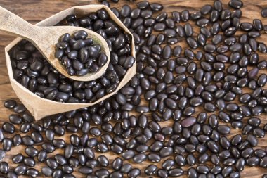 Ahşap arka plan üzerinde ham siyah fasulye