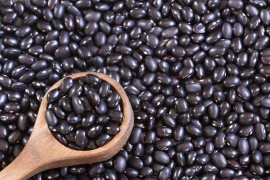 Ahşap arka plan üzerinde ham siyah fasulye