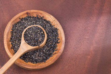 Siyah susam - Sesamum indicum organik tohumları. Ahşap arka plan