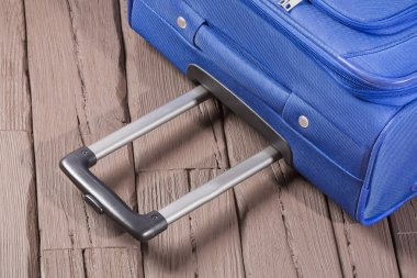 Modern mavi seyahat bavul - ahşap arka plan