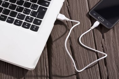 Telefon bilgisayara - ahşap arka plan bağlı