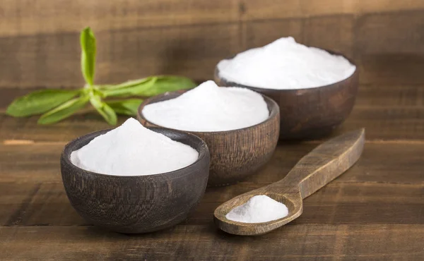 Natural sweetener in powder from stevia plant - Stevia rebaudiana. Wooden background