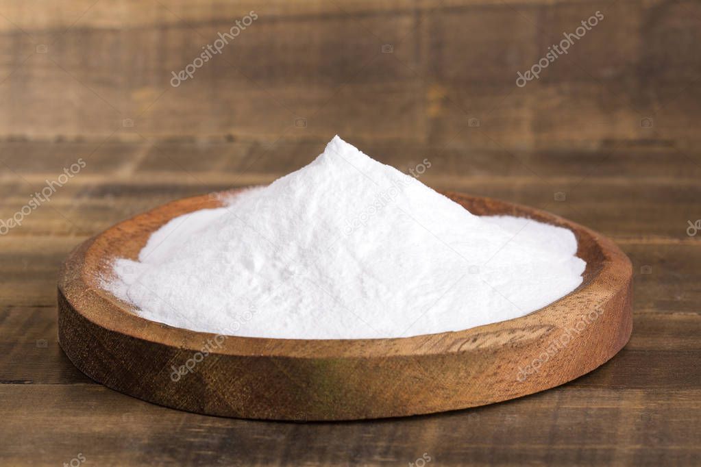 Natural sweetener in powder from stevia plant - Stevia rebaudiana. Wooden background