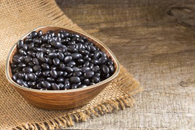 Ahşap arka plan üzerinde ham siyah fasulye