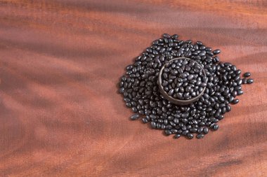 Ahşap arka plan üzerinde ham siyah fasulye