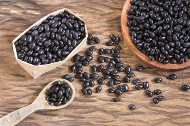 Ahşap arka plan üzerinde ham siyah fasulye