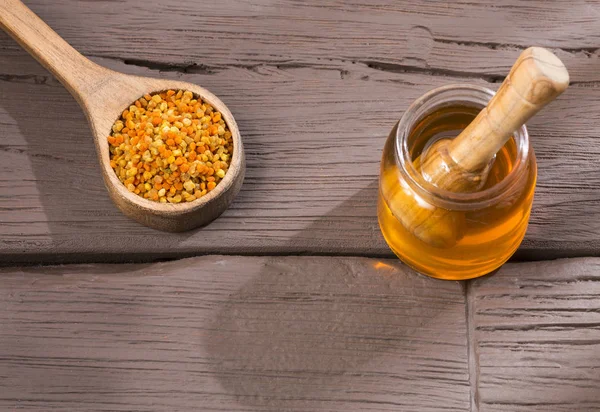 Bee honey and pollen grains. Natural sweetener. Wood background