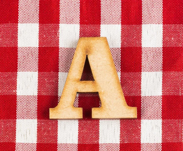 Letter A of the alphabet - Red checkered fabric tablecloth.