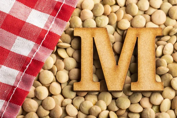 Letter M, Lentils with checkered napkin - Top view